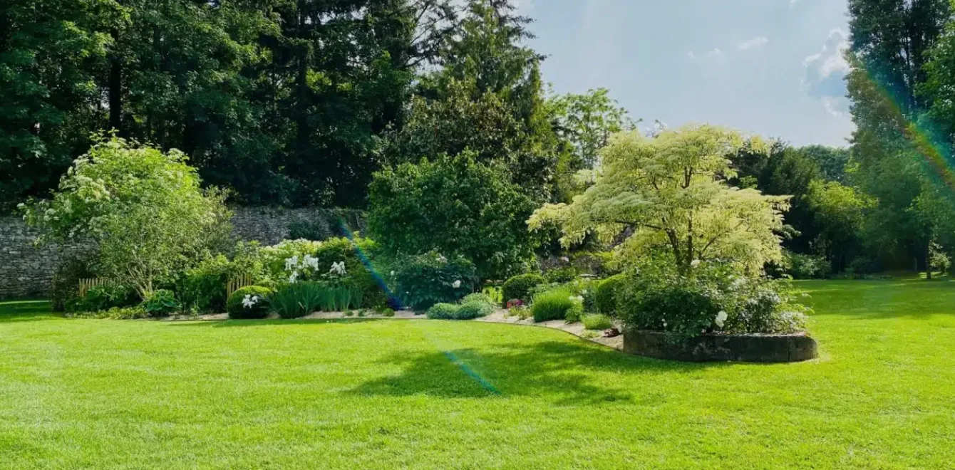 Grand jardin paysager aux pelouses et massifs soignés
